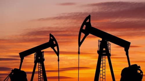 Oil Pumps Silhouetted Against Fiery Sunset Sky