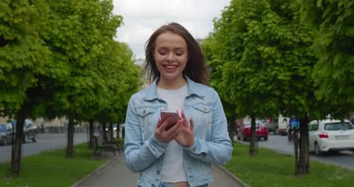 The Girl Is Walking Down the Alley and Texting