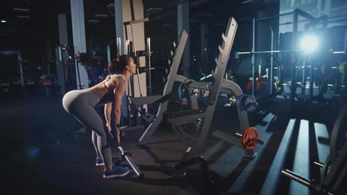 Fit Woman Lifting Weights in Gym