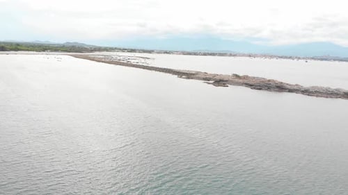 An Unmanned Shot of the Rocky Peninsula Against the Backdrop of the Sea and Small Fishing Corals