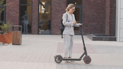 Femme d'affaires conduisant un scooter électrique