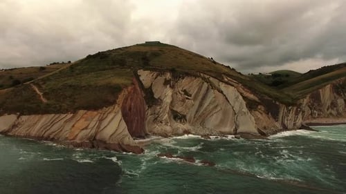 Stormy sea waves splashing on rocky cliff