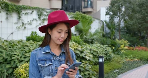 Smiling Woman Using Mobile Phone Outdoors