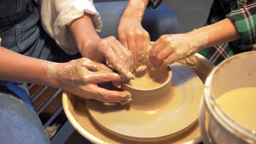 Boy and Woman Works with Pottery Wheel in a Workshop