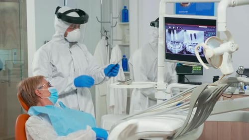 Dentist Examining Patient With X-Ray in Office
