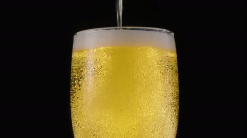 Pouring Beer into Glass with Bubbles and Foam