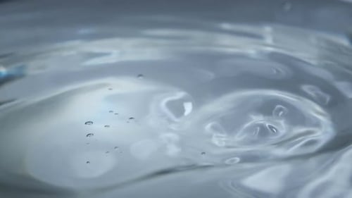 Water Drop Falls on the Water Surface in Slow Motion Macro Shot