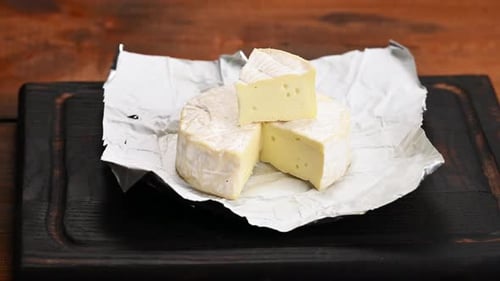 round brie cheese on brown wooden cutting board