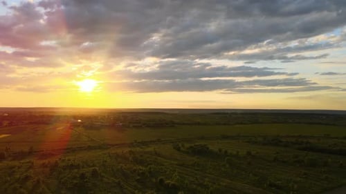 Aerial landscape view of cultivated agricultural fields on vibrant summer evening.