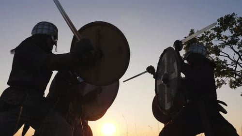 Silhouetted Warriors Fighting with Swords at Sunrise