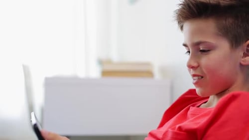 Boy Smiles and Interacts with Cell Phone Indoors