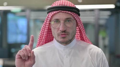 Man in Headdress Raises Index Finger