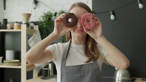 Cheerful Woman Posing with Donuts in Kitchen