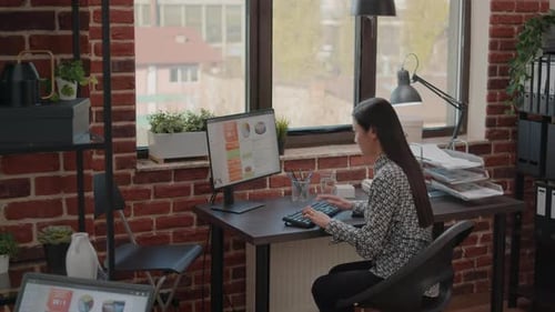 Woman Typing on Computer at Workplace Desk