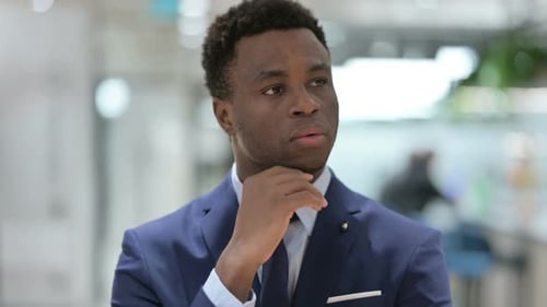 Thoughtful Man in Suit Thinking in Workplace