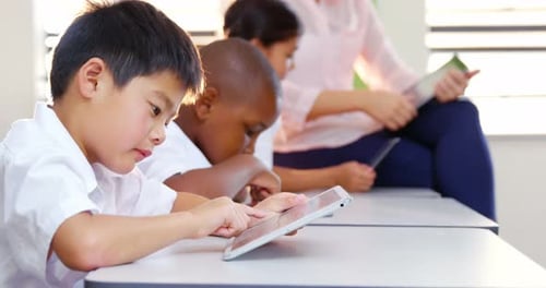 School kids and teacher using digital tablet in classroom