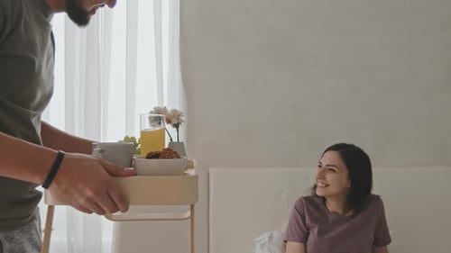Husband Bringing Breakfast In Bed To His Beautiful Wife