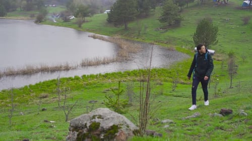 Man with Backpack Hiking near Mountain Lake