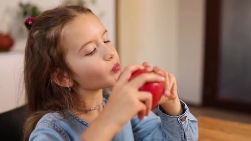 Child Eats Red Apple, Close Up Indoor View