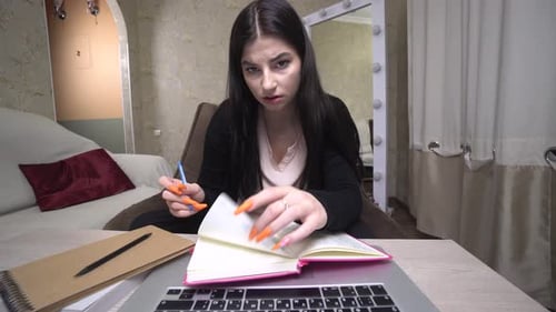 Young Woman Studying, Taking Notes at Home