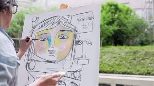 Junge Künstlerin malt zeitgenössische Kunst auf Leinwand im Freien