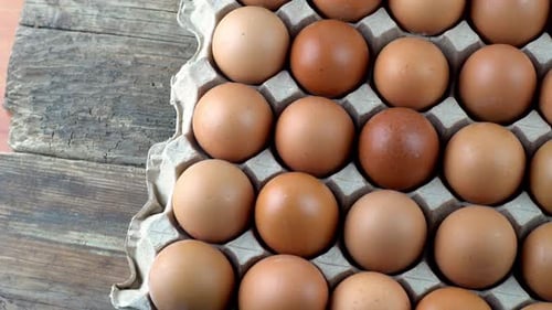 Fresh Brown Eggs in Carton on Rustic Wood Table