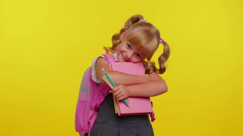 Adorable Schoolgirl Smiling, Holding Books in Studio