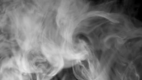 Abstract Smoke Floating Through Space Against Black Background - studio shot