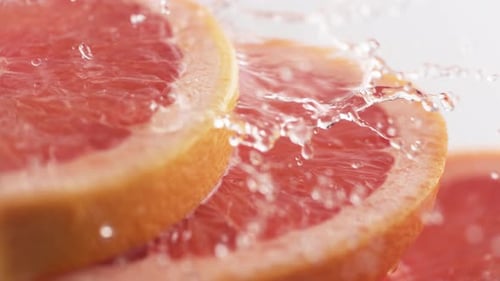 Water Pouring Over Grapefruit Slices in Close Up
