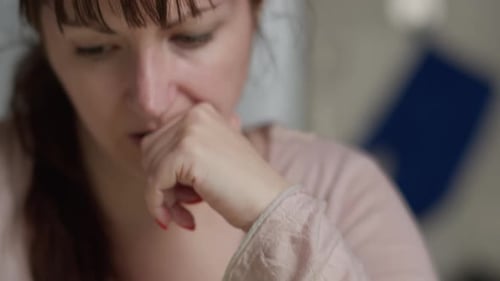 Woman Worried About Finances Holding Head in Hands