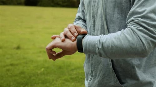 Man Using Smart Watch in Field
