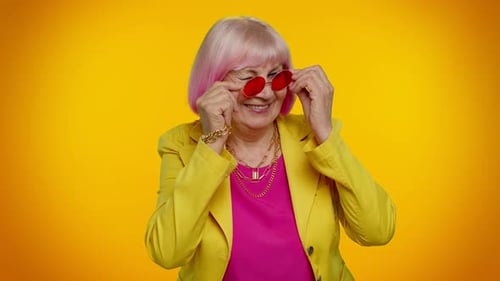 Stylish Senior Woman Puts on Red Glasses