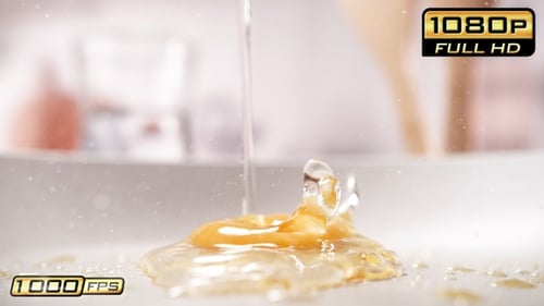 Egg yolk and white splashing in greasy pan