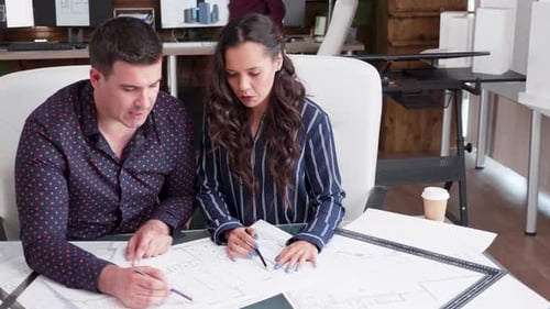 Contructor Engineer and Female Architect Working in a Office with Blueprints