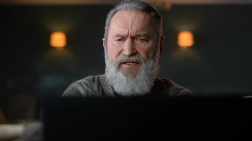 Senior Man Concentrating Hard at Computer