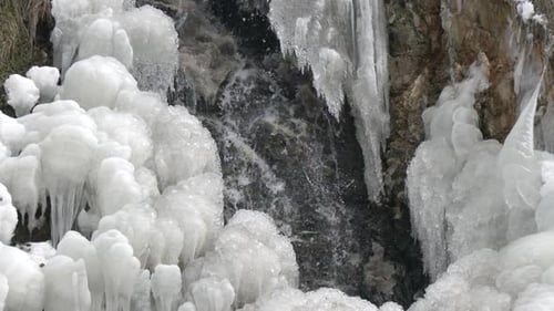 Icy Waterfall Flowing in Winter Landscape