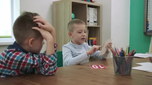 Two Children Learning at Table in Classroom