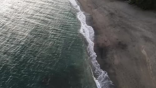 Aerial View of Ocean Waves Meeting Sandy Beach