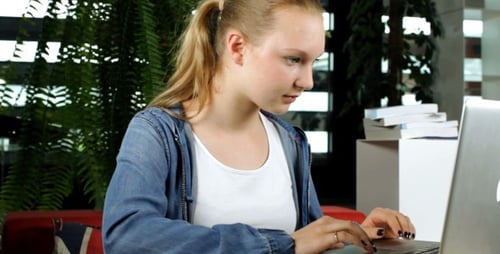 Student arbeitet am Laptop und macht Notizen