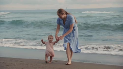 Mother Holding Daughters Hand by Ocean