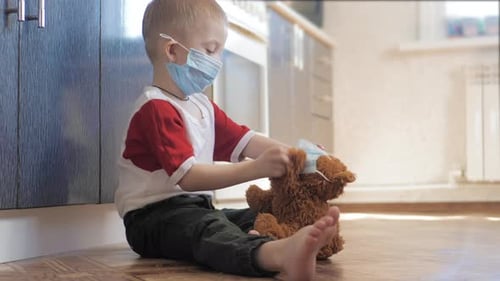 Cute Child Playing with Teddy Bear Wearing Masks