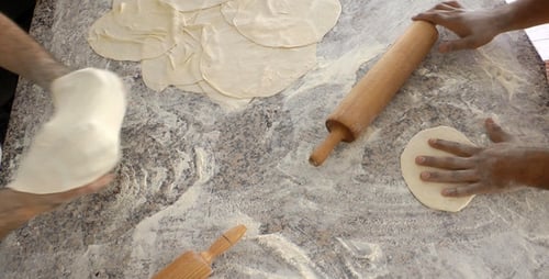 Baker Making Pitas With Roller