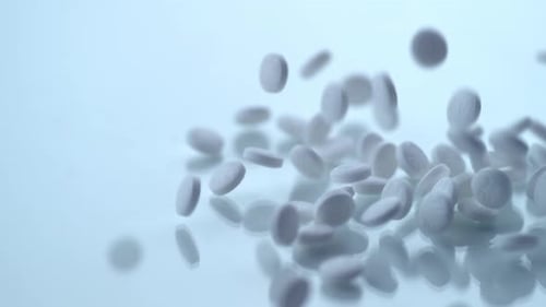 White Pills Falling in Slow Motion