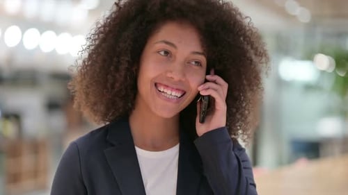 Young Woman Talking on Phone in Modern Office