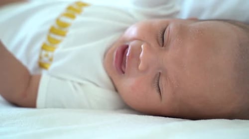 Close Up Shot of Crying Newborn Baby on Bed at Home