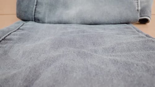 Dark Denim Pants Leg Lying on Table in Beige Studio Room