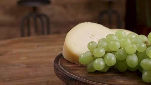 Cheese and Green Grapes on Wooden Platter