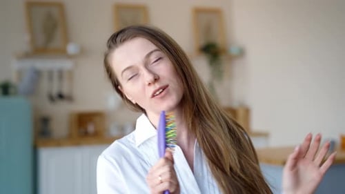 Cheerful Woman Singing with Hairbrush Microphone