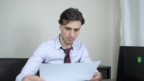 Young Adult Man Working on Laptop at Desk
