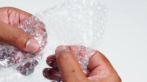 Close Up Hands Popping Bubbles in Bubble Wrap
